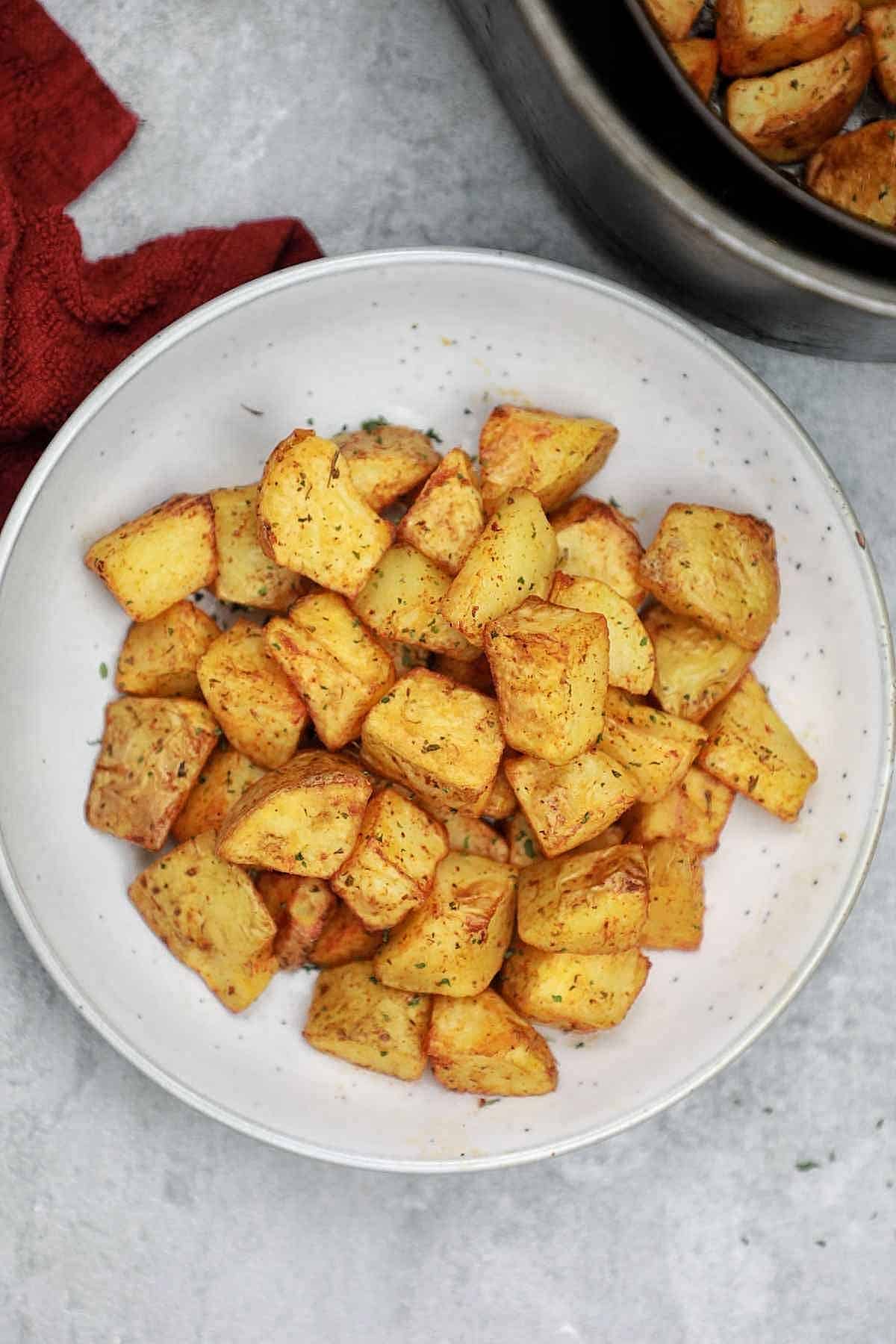 air fryer cubed potatoes served on a light blue plate.