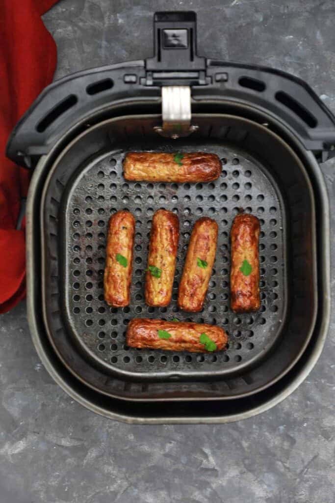 sausages in air fryer basket.