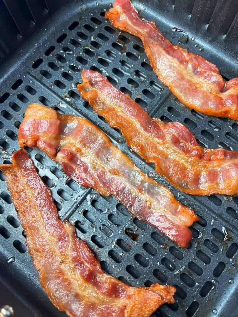 air fryer bacon slices in AF basket.