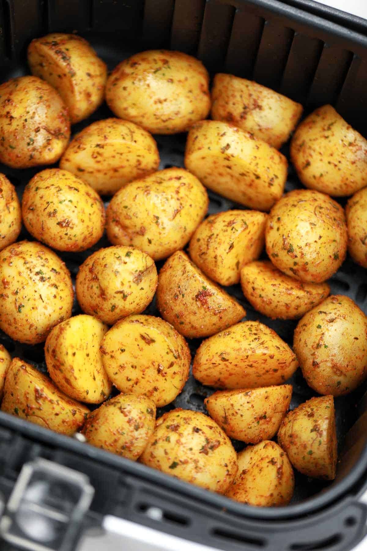 seasoned mini potatoes in air fryer basket.