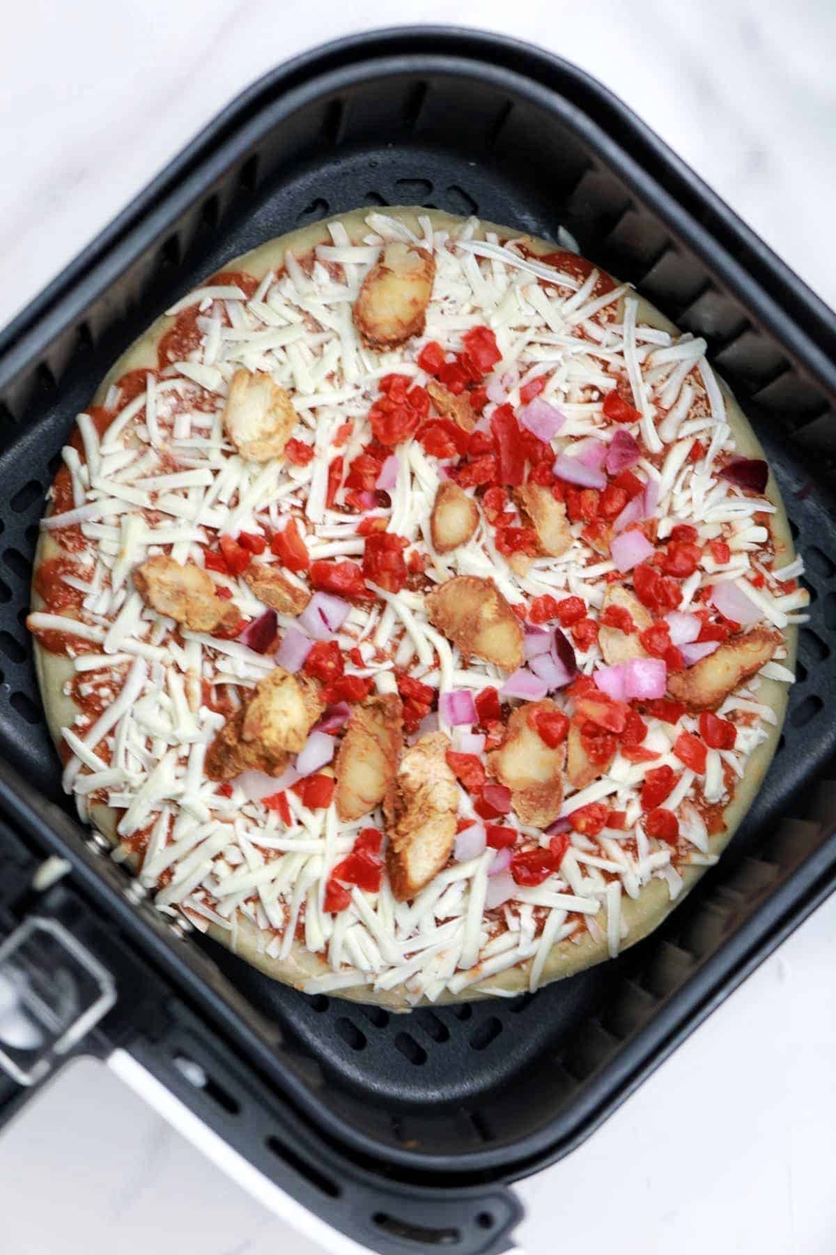 frozen pizza in air fryer basket.