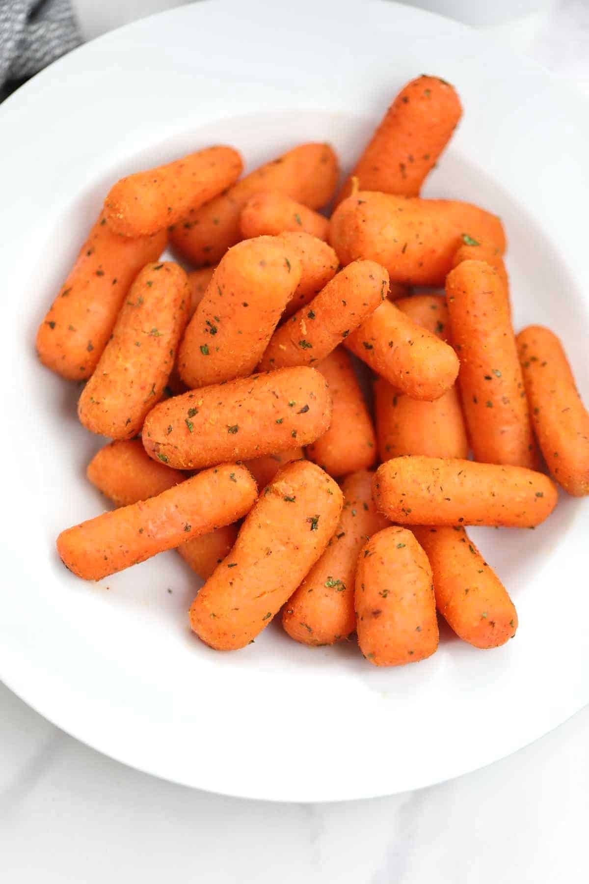 air fryer baby carrots on a white plate.