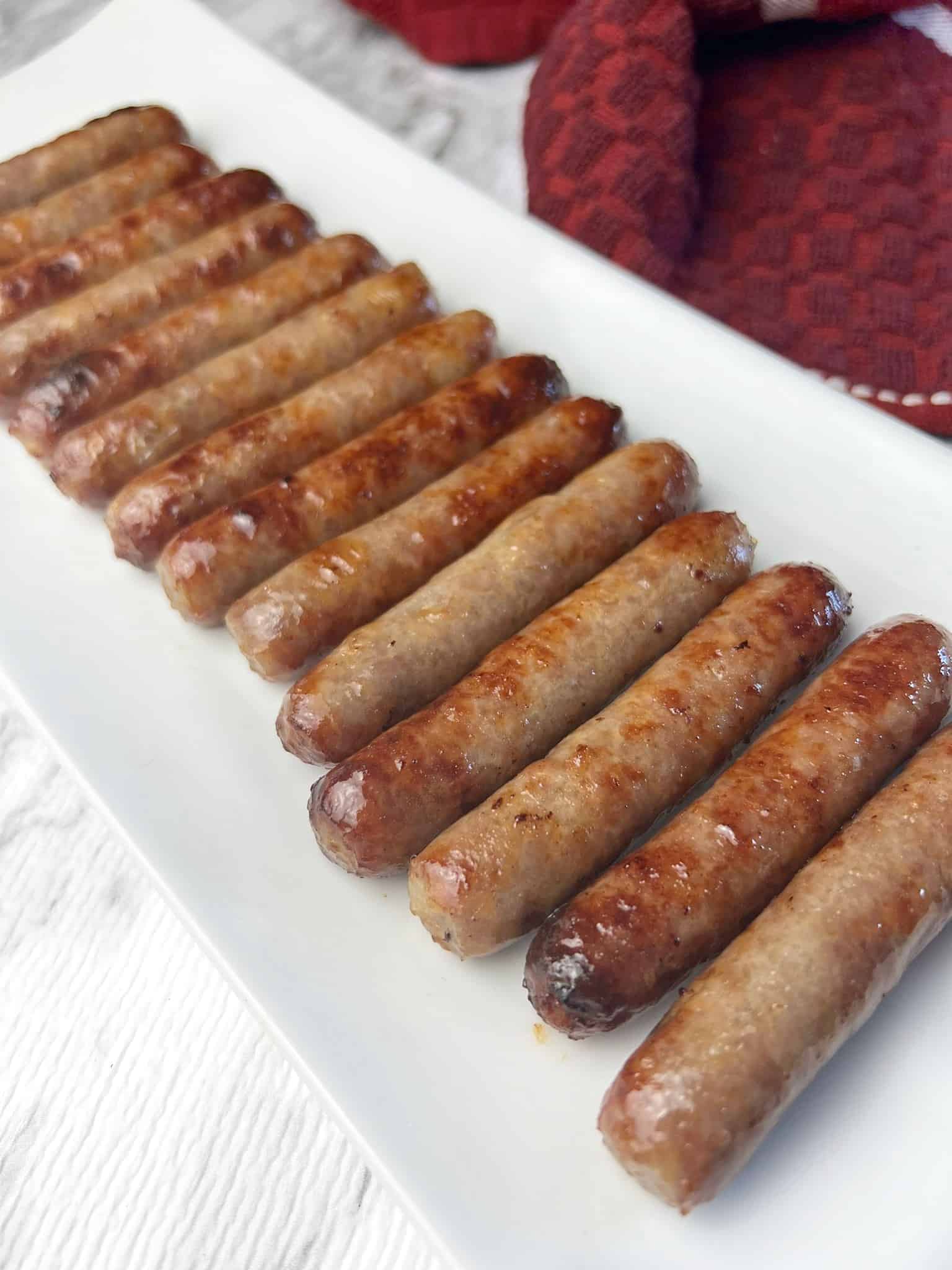 breakfast sausages served on a white plate.